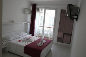 a bedroom with a bed with stuffed animals on it at Scala Nuova Annex in Cesme