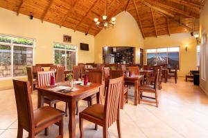 a dining room with wooden tables and chairs at Mrimba Palm Hotel in Arusha
