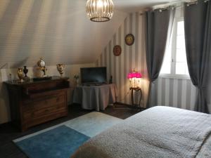 1 dormitorio con 1 cama y 1 mesa con TV en Angelina et ses animaux, en Pléchâtel