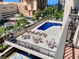 un balcón con vistas panorámicas a una piscina con mesas y sillas en Palms Waikiki #412, en Honolulu