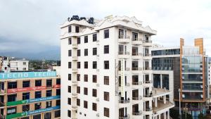 a tall white building in front of some buildings at Natron Palace Hotel in Arusha