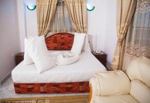 a bedroom with a bed and a couch at Natron Palace Hotel in Arusha