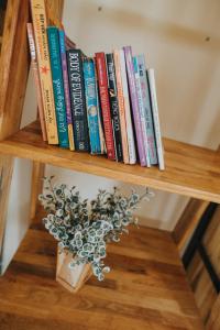 a book shelf with books and a vase on it at Nai's house - Homestay in Thanh Hải