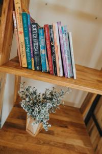 un estante de libros con libros y un jarrón. en Nai's house - Homestay, en Thanh Hải
