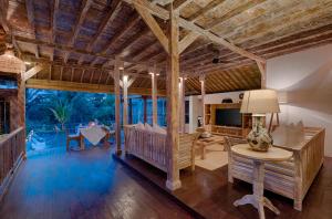 sala de estar con techo de madera y mesa en Villa Bedauh Wetan, en Ubud