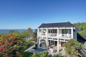 Elle offre une vue aérienne sur une maison blanche dotée d'un balcon. dans l'établissement Christchurch - Art space, sea views, private, à Christchurch