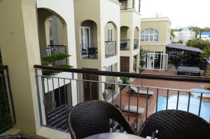 balkon ze stołem i krzesłami w budynku w obiekcie Villa Narmada w mieście Grand Baie