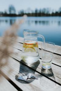 einen Krug Wasser und zwei Gläser auf einem Holztisch in der Unterkunft Sielanka Mazurska in Lepaki Wielkie