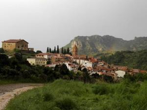 a village on a hill with a rainbow in the background at Antigua Casa Pepo y Casa Marieta in Herbés