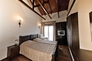 Un dormitorio con una cama y un televisor. en Villa Theano, en Agios Nikolaos 33 fotos más