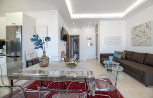- un salon avec une table en verre et un canapé dans l'établissement Agios Titos Luxury Home, à Héraklion