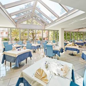 comedor con mesas y sillas y techo de cristal en Hotel Europa, en Grado