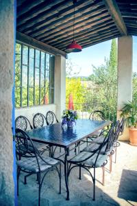 a table and chairs on a patio with a window at Chambres d'Hôtes et Gîtes Le Mas Bleu & Spa Resort in Rosières