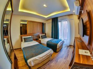ein Hotelzimmer mit 2 Betten und einem TV in der Unterkunft DİAMOND LİMAN HOTEL in Bartın
