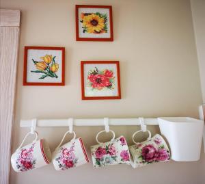 a row of embroidered pillows hanging on a wall at Rita's Guest House in Palanga