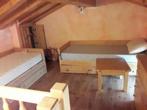 Habitación con 2 camas y mesa. en Residenza il bosco en Prada