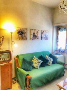 uma sala de estar com um sofá verde com almofadas em Intero Appartamento dei Pini - posto auto incluso - 4 piano senza ascensore em Tivoli