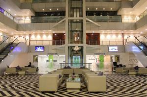 a lobby with couches and tables in a building at The Byke Suraj Plaza Pure Veg, Thane in Thane