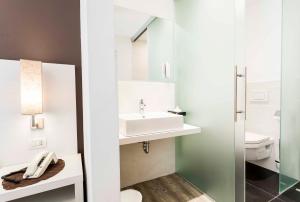 a bathroom with a sink, toilet, and bathtub at Business Resort Parkhotel Werth in Bolzano