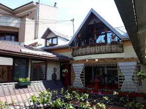 a house with a balcony with flowers on it at Gabi Guesthouse in Constanţa
