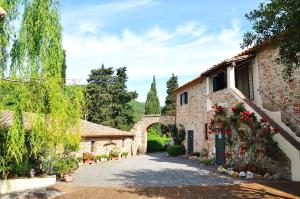an entrance to a building with flowers on a driveway at Agriturismo Terenzana in Riparbella