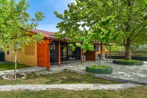 a house with trees in front of it at Platanes Apartments in Skala Marion