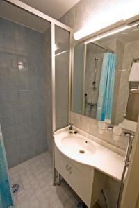 ein Bad mit einem Waschbecken und einem Spiegel in der Unterkunft Mango Hotel in Tampere