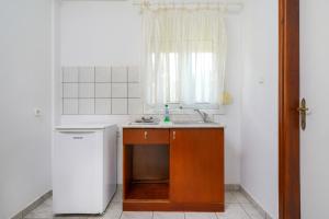 a small kitchen with a sink and a window at Pension Lakis in Prinos