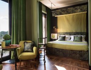 um quarto com uma cama, uma mesa e uma cadeira em Velona's Jungle Luxury Suites em Florença