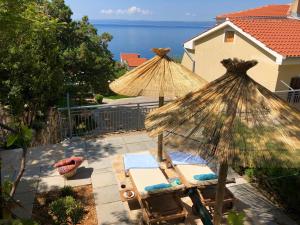 a patio with two umbrellas and two chairs at Sunshine Residence in Stara Baška