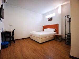 ein Schlafzimmer mit einem Bett, einem Tisch und einem Stuhl in der Unterkunft Amanjaya Hotel in Sungai Petani