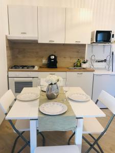 kuchnia ze stołem z białymi krzesłami, stołem i szezlongiem w obiekcie Happy House Bogliasco w mieście Bogliasco