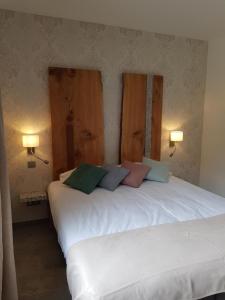 duas camas num quarto com duas lâmpadas na parede em Hôtel de la Restonica em Corte