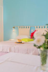 a bed with a hat and a vase of flowers at Kassiani Studios in Plakias