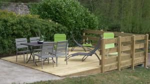 una terrazza in legno con tavolo e sedie. di Au ruisseau de Belle Isle a Echinghen