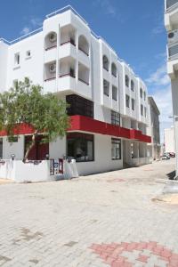 a white building with a red stripe on it at Scala Nuova Annex in Cesme