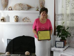 a woman holding a plaque in a room at Afroditi in Panormos Skopelos