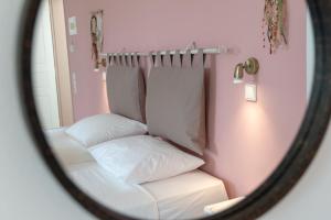 a mirror reflection of a bed in a pink room at Kassiani Studios in Plakias