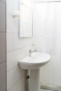 a white sink sitting under a mirror in a bathroom at Guesthouse Villa Juri in Berat