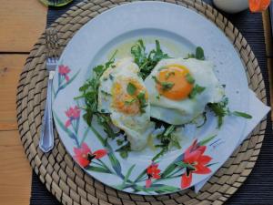 a plate of food with eggs on a table at Small Paradise in Andros
