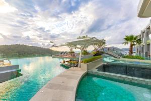 uma piscina num resort com um barco em Crest Resort & Pool Villas - SHA Extra Plus em Praia de Patong