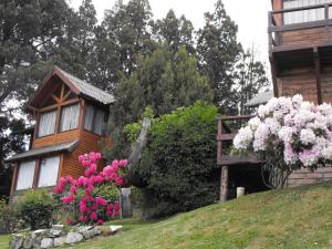 a house with flowers on a hill next to a building at Vientos Del Sur in San Carlos de Bariloche