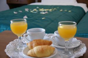 a table with two glasses of orange juice and croissants at Afroditi in Panormos Skopelos