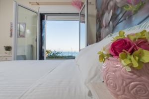 a pink vase with flowers on top of a bed at Boutique Apartment Volos in Volos