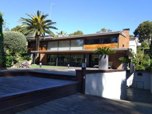 a house with a palm tree in front of it at VILLA DEL BOSQUE in Castelldefels