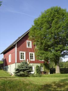 a red barn with a tree in front of it at Basislager Hohnstein - Familie Lösel in Ehrenberg
