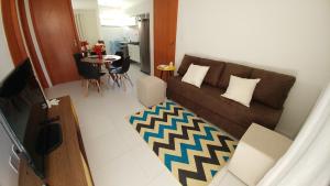 ein Wohnzimmer mit einem Sofa und einem Tisch in der Unterkunft Condomínio Residencial Sossego na Beira do Rio in Paulo Afonso
