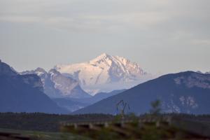 a snow covered mountain in the distance with a road at Chez Michelle et Dany - Chambres d'hôtes proche d'Annecy in Vaulx