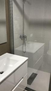 a white bathroom with a shower and a sink at Urbanización loureiral in Baiona