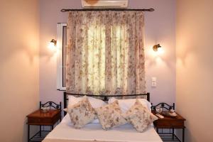 a bedroom with a bed with pillows and a curtain at BETTY'S HOUSE in Pythagoreio